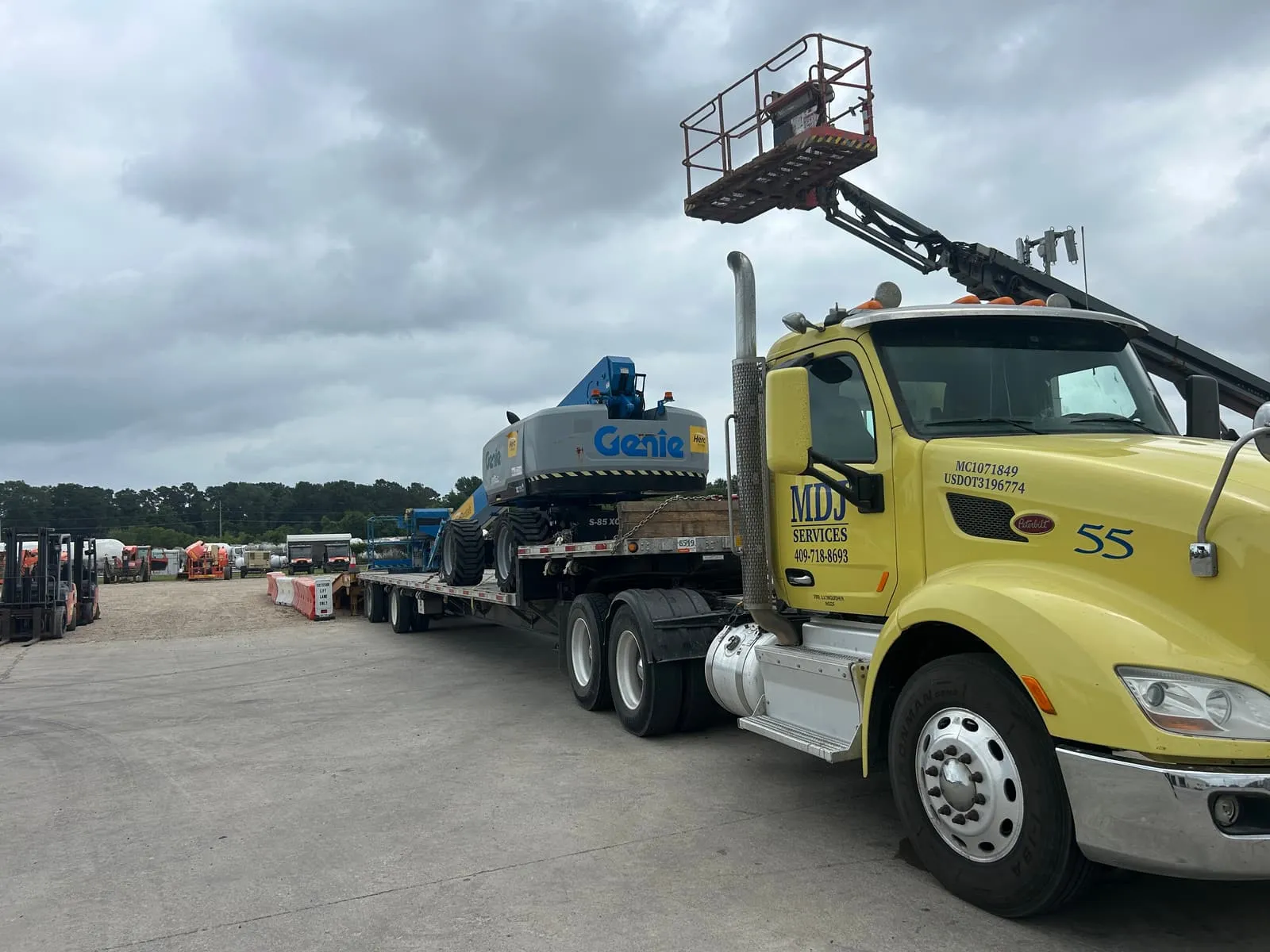 MDJ Services Peterbilt hauling a Genie boom lift on a step deck trailer in Southeast Texas